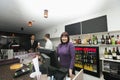 Portrait of female cashier with manager and bartender at bar counter
