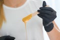 Portrait of a female caucasian beautician holding a jar of sugar paste for sugaring