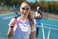 Portrait of female caucasian player with african american competitor standing at court