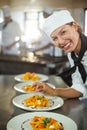 Portrait of female chef garnishing plate of food Royalty Free Stock Photo