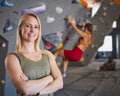 Portrait Of Female Coach In Front Of Climbing Wall At Indoor Centre With Climber In Background Royalty Free Stock Photo