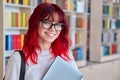 Portrait of female college student in glasses with laptop backpack, looking at camera Royalty Free Stock Photo