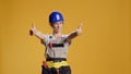 Portrait of female construction worker giving thumbs up in studio Royalty Free Stock Photo