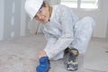 Portrait female contractor sanding floor