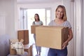 Portrait Of Female Couple Carrying Boxes Through Front Door Of New Home On Moving Day Royalty Free Stock Photo