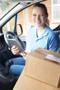 Portrait Of Female Courier In Van With Digital Tablet Delivering