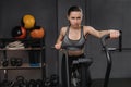 Crossfit female athlete practicing on airbike at gym