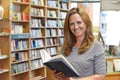 Portrait Of Female Customer Reading Book In Bookstore Royalty Free Stock Photo