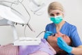 Female dentist with male patient during dental cure Royalty Free Stock Photo