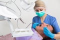 Female dentist with male patient during dental cure Royalty Free Stock Photo