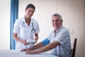 Portrait of female doctor checking blood pressure of senior man Royalty Free Stock Photo