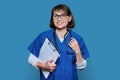 Portrait of female doctor with clipboard looking at camera on blue background Royalty Free Stock Photo