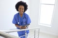 Portrait Of Female Doctor Or Nurse With Digital Tablet Checking Patient Notes On Stairs In Hospital Royalty Free Stock Photo