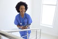 Portrait Of Female Doctor Or Nurse With Digital Tablet Checking Patient Notes On Stairs In Hospital Royalty Free Stock Photo