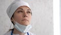 Female doctor or nurse in uniform very tired after receive patients in hospital. Hard work, medical, epidemic concept Royalty Free Stock Photo