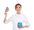 Portrait of female doctor with piggy bank and money Royalty Free Stock Photo