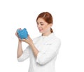 Portrait of female doctor putting coin into piggy bank Royalty Free Stock Photo