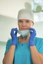 Portrait of female doctor removing surgical mask at clinic