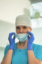 Portrait of female doctor removing surgical mask at clinic