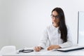 Portrait of female doctor sitting at the desk and writing something while working in office. Royalty Free Stock Photo