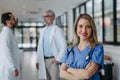 Portrait of female doctor standing in hospital corridor. Beautiful nurse in uniform, stethoscope around neck standing in Royalty Free Stock Photo