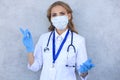 Portrait of female doctor with stethoscope in mask  over grey background Royalty Free Stock Photo
