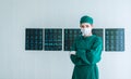 Portrait of Female doctor Surgeon in green scrubs putting on surgical gloves and looking at Camera . Young asian doctor woman with Royalty Free Stock Photo