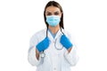 Portrait of female doctor wearing face mask holding stethoscope against white background Royalty Free Stock Photo