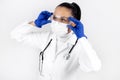 Portrait of female doctor wearing protective mask, glasses and gloves against white background. Royalty Free Stock Photo