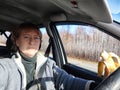 Portrait of female driver in solo journey. Adult mature middle aged woman holding steering wheel and banana. Eating