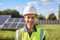 Portrait Of Female Engineer Inspecting Solar Panels In Field Generating Renewable Energy