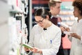 Portrait of a female experienced pharmacist reading indications