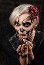 Portrait of female face with sugar skull makeup holding spider in hands. Face painting art Royalty Free Stock Photo