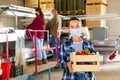 Female farmer in protective mask standing with crate of strawberries at farm warehouse Royalty Free Stock Photo