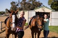 Portrait female friends with horses