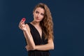 Portrait of the female gambler at the casino keeping poker chips in the hand