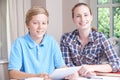 Portrait Of Female Home Tutor Helping Boy With Studies Using Dig Royalty Free Stock Photo