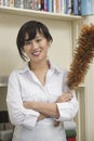 Portrait of female housekeeper holding feather duster Royalty Free Stock Photo