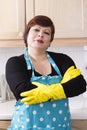 Portrait of female houseworker dusting kitchen