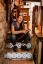 Portrait of a female leather artisan in her workshop with hand-made belt