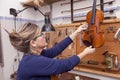 Portrait of female mature violin maker while testing the violins Royalty Free Stock Photo