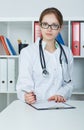 Portrait of female medicine doctor holding silver pen writing something on clipboard closeup. Royalty Free Stock Photo