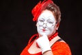 Portrait of female mime artist, isolated on black background. Racy woman touches her chin with a finger looking languid Royalty Free Stock Photo