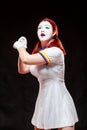 Portrait of female mime artist, isolated on black background. Young woman pretends playing tennis, holding the racket Royalty Free Stock Photo