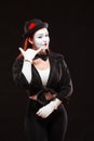 Portrait Of Female Mime Artist Performing, Isolated On Black Background. Woman Is Pretending Speaking By The Phone