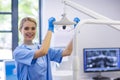 Portrait of female nurse adjusting dental light