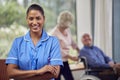 Portrait Of Female Nurse Or Care Worker Making Home Visit To  Senior Couple With Man In Wheelchair Royalty Free Stock Photo