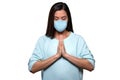 Portrait of a female nurse in surgical mask keeping calm during world pandemic scare, praying hands isolated on white background
