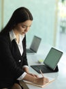 Female office worker in black suit planing her schedule on office table Royalty Free Stock Photo