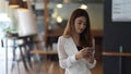 Female office worker using smartphone while take a break in office room Royalty Free Stock Photo